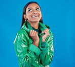 Gen z, Indian woman and fashion aesthetic of a young female in a isolated studio. Smile, happiness and raincoat for cold weather with blue background and person feeling happy from youth and style