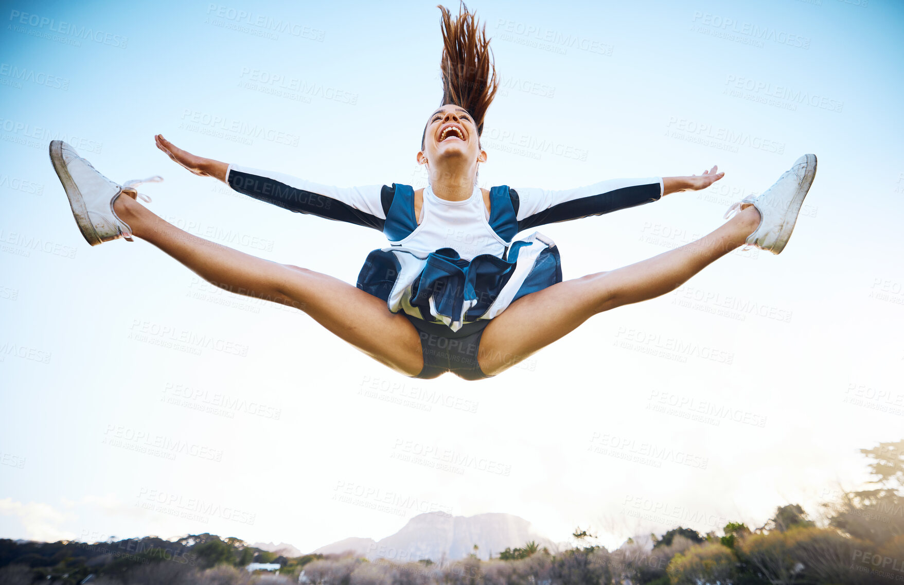 Buy stock photo Cheerleader woman, sky and sports performance with smile and energy to celebrate outdoor. Cheerleading person dance or jump stunt while laughing with joy for training workout, freedom or competition
