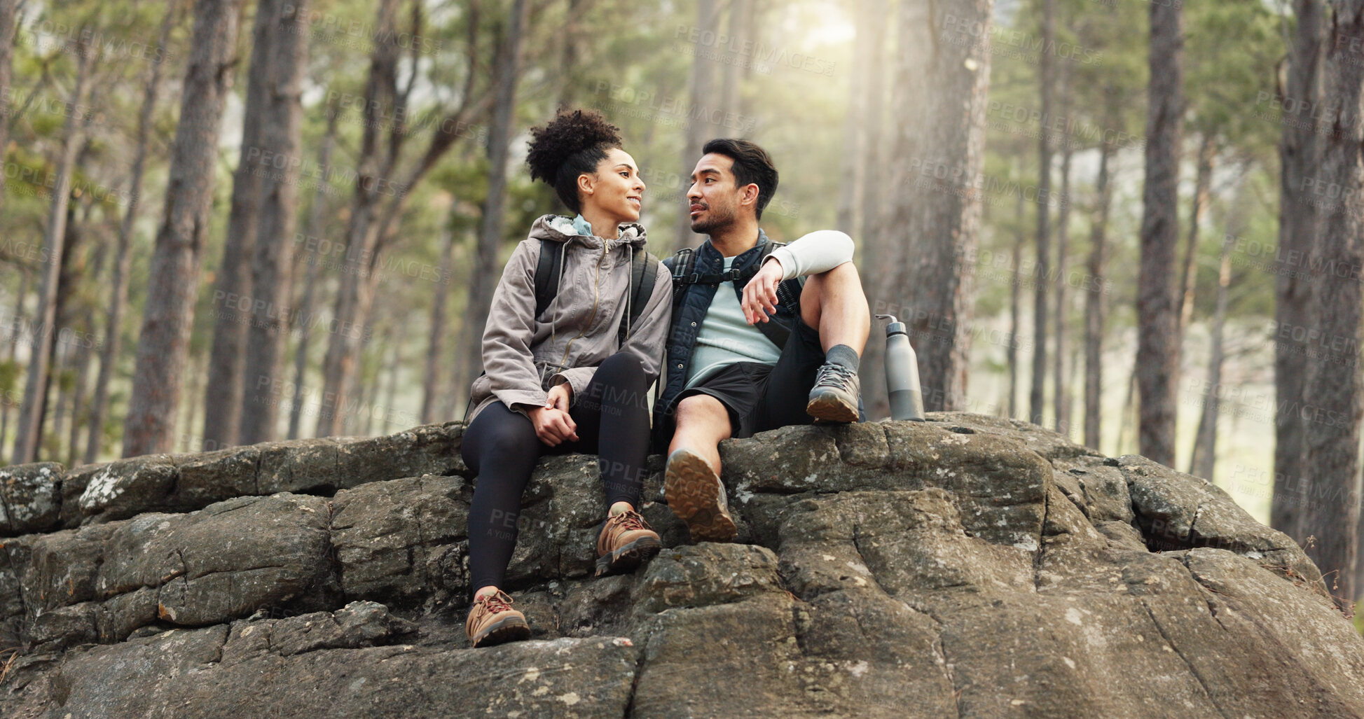 Buy stock photo Love, hiking and a couple relax on adventure trail in forest and sitting on a rock with wellness. Health, man and woman with vacation, natural landscape and marriage with fitness and freedom with fun