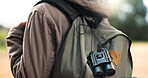 Traveler, bag and adventure walk to explore, sightsee or scout trip in the outdoors of nature. Closeup of adventurer walking for backpacking, travel or tour with binoculars in the natural environment