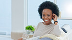 Portrait of a happy afro woman relaxing at home on the weekend. Beautiful casual African American female smiling and enjoying a relaxed Sunday afternoon in her bright living room with copy space