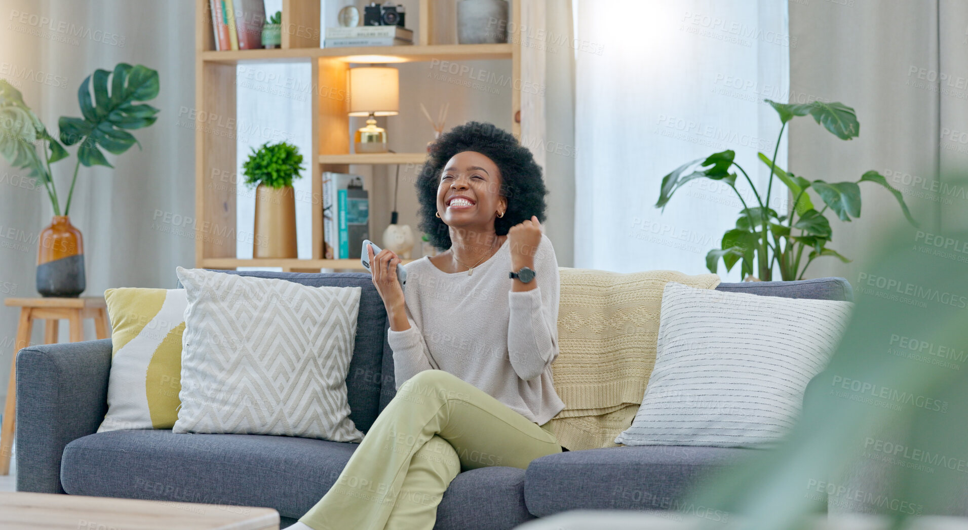 Buy stock photo Black woman, phone and celebration on sofa in winning, promotion or lottery prize in living room at home. Excited African female person smile with afro in success, victory or good news at house