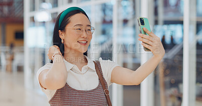 Buy stock photo Video call, phone and Asian woman in the airport for travel in communication or conversation. Happy, technology and young female person on a virtual discussion with cellphone in a modern hotel lobby.