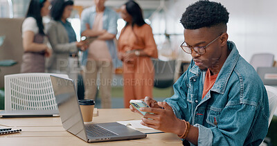 Phone, laptop and creative man in the office networking on social media, mobile app and the internet. Technology, planning and African male marketing employee doing research and working on a project.