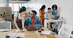 Teamwork, laptop and business people fist bump in office for  success celebration. Training, coaching and Asian woman teaching black man, support and advice while celebrating after solving problem.