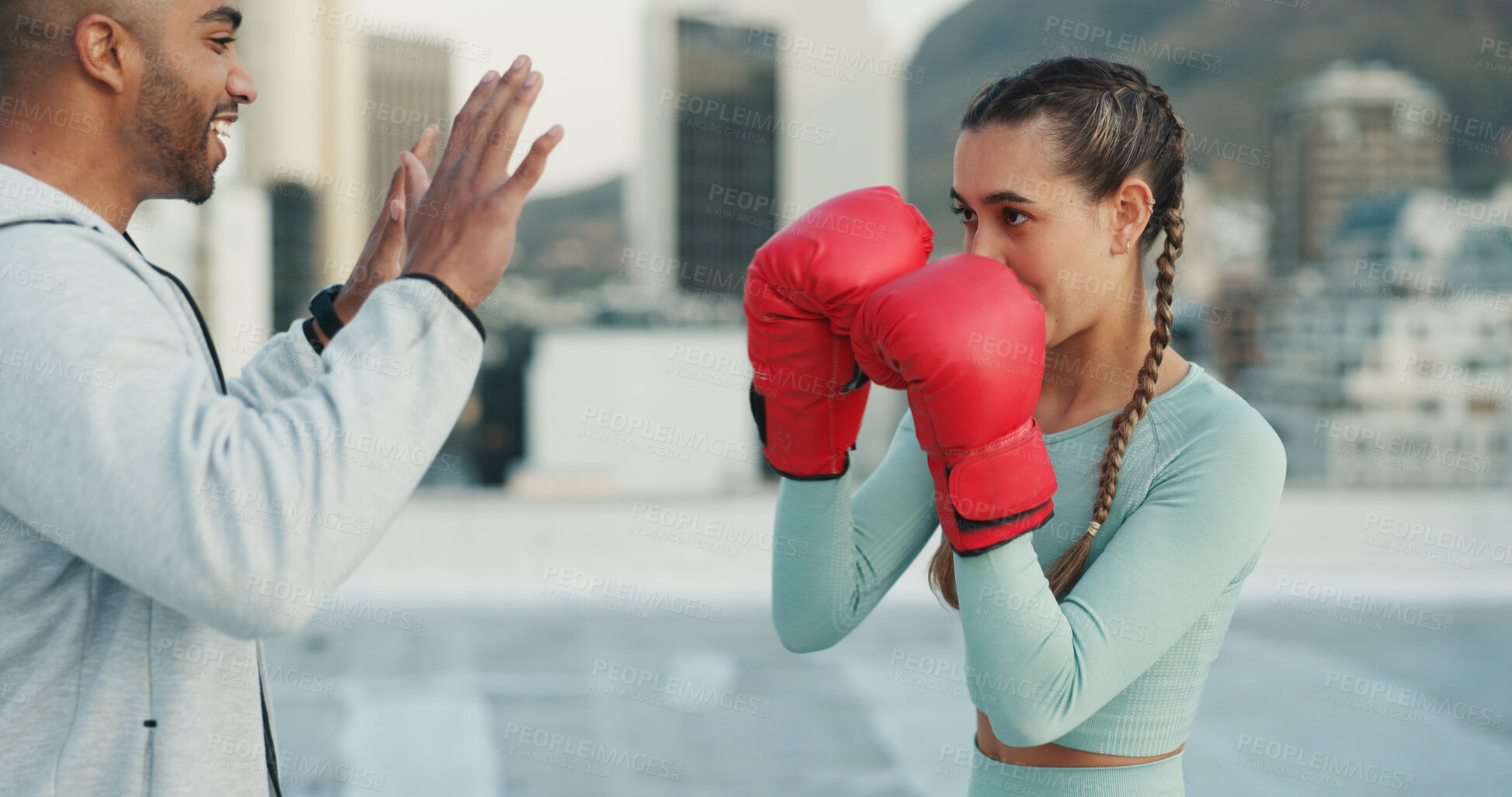 Buy stock photo Boxing, coach and woman outdoor for training on rooftop in a city. Couple of friends, athlete and boxer gloves with personal trainer man for martial arts workout, exercise and fight for combat sports