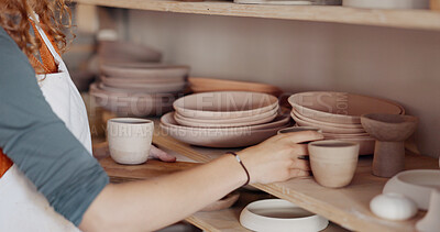 Pottery woman, shelf and creative ceramic cups with artist or craft person standing in artisan workshop or art studio. Entrepreneur potter female enjoy hobby making art to sell in startup business