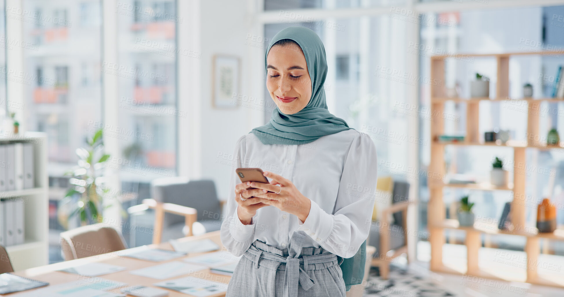 Buy stock photo Muslim, phone or businesswoman typing on social media for communication or texting in startup office. Search, smile or Islamic worker in online conversation on mobile app to scroll on internet or web