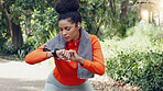 Woman checking her pulse with a smart watch while on a health, fitness and wellness run in nature. Active girl on a jog for a cardio exercise in an outdoor park with an activity tracker and towel.