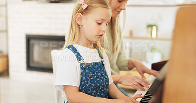 Music development, girl learning piano and musical note education from mom in the home living room. A child musician playing keys, learn creative audio art and fun concert performance in family house