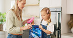 Backpack, kitchen and mother with child for school lunchbox, sandwich and healthy food for nutrition, wellness and development. Helping, support and care of a mom with her kid bag for back to school