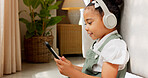 Tablet game, headphones and relax child gaming, having fun or play online games on mobile device or digital tech app. Kid entertainment, youth lifestyle and young gamer girl playing on ui touchscreen