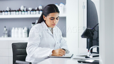 Young scientist using a computer and microscope in a lab. Female pathologist analyzing medical samples while doing experiments to develop a cure. Microbiologist conducting forensic research