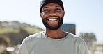 Happy black man standing outdoor in the city with a smile on his face. Portrait, freedom and carefree with a young male gesturing or signing in a town