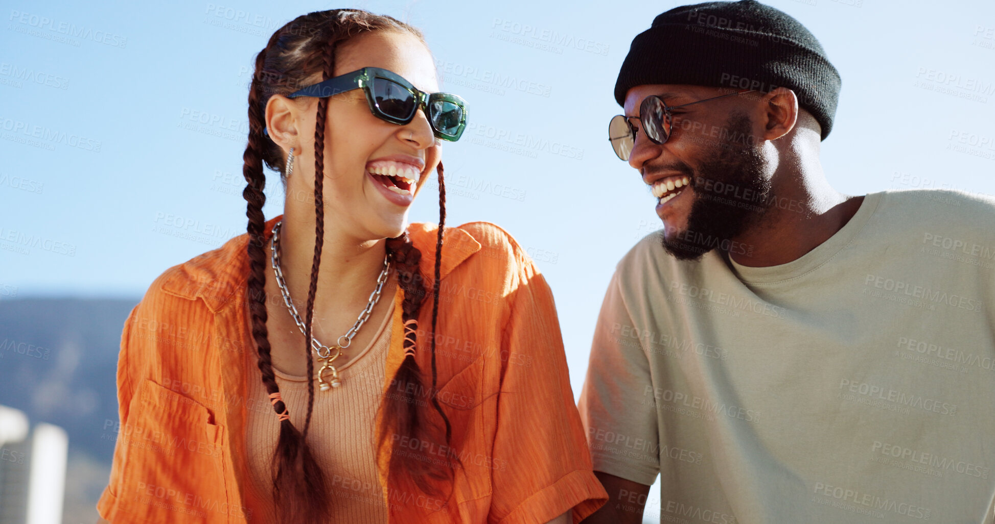 Buy stock photo Couple of friends, rooftop and laughing on city building, fun and youth in happy social bonding on summer sky. Diversity, gen z man and woman on roof with smile, love and relax on urban date together