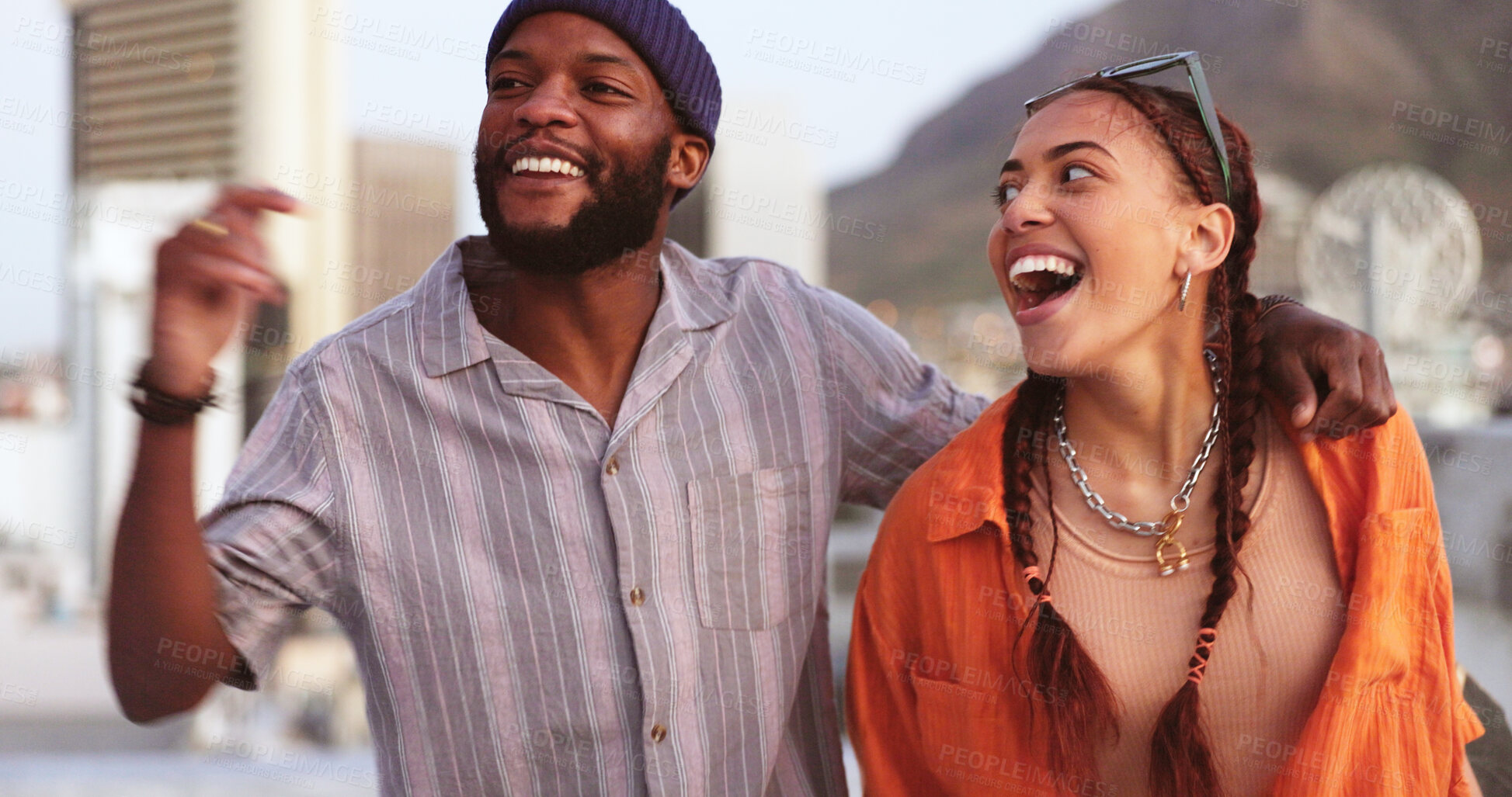 Buy stock photo Happy, conversation and young couple in the city on rooftop of building with freedom, energy and love. Smile, laughing and interracial man and woman talking, walking and bonding on balcony in town.