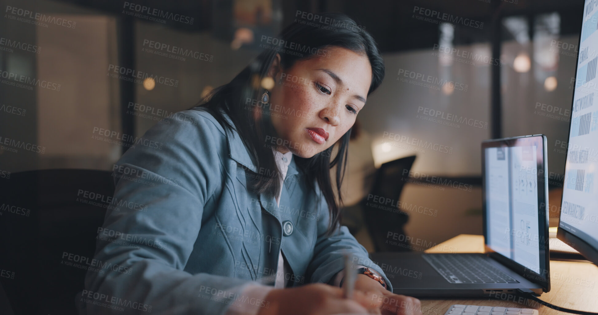 Buy stock photo Asian woman, night and work at computer, writing and research notes with manager at creative agency. Office, late and designer thinking of website idea, technology and webdesign deadline at overtime