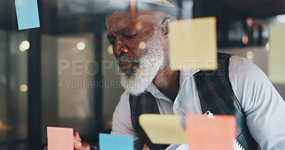 Strategy, planning and black man with sticky notes on glass wall brainstorming for new project. Development, motivation and small business startup at at night, man thinking and writing notes for idea