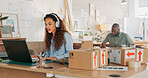 Video call, customer service woman in a courier office for product consulting, sales negotiation or ecommerce. Logistics, customer support or business consultant laptop, headphones and shipping boxes