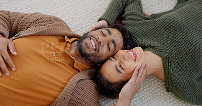 Kiss, love and couple on the floor of their living room to relax with happiness together in their house. Comic, happy and man and woman with smile for affection and funny conversation from above