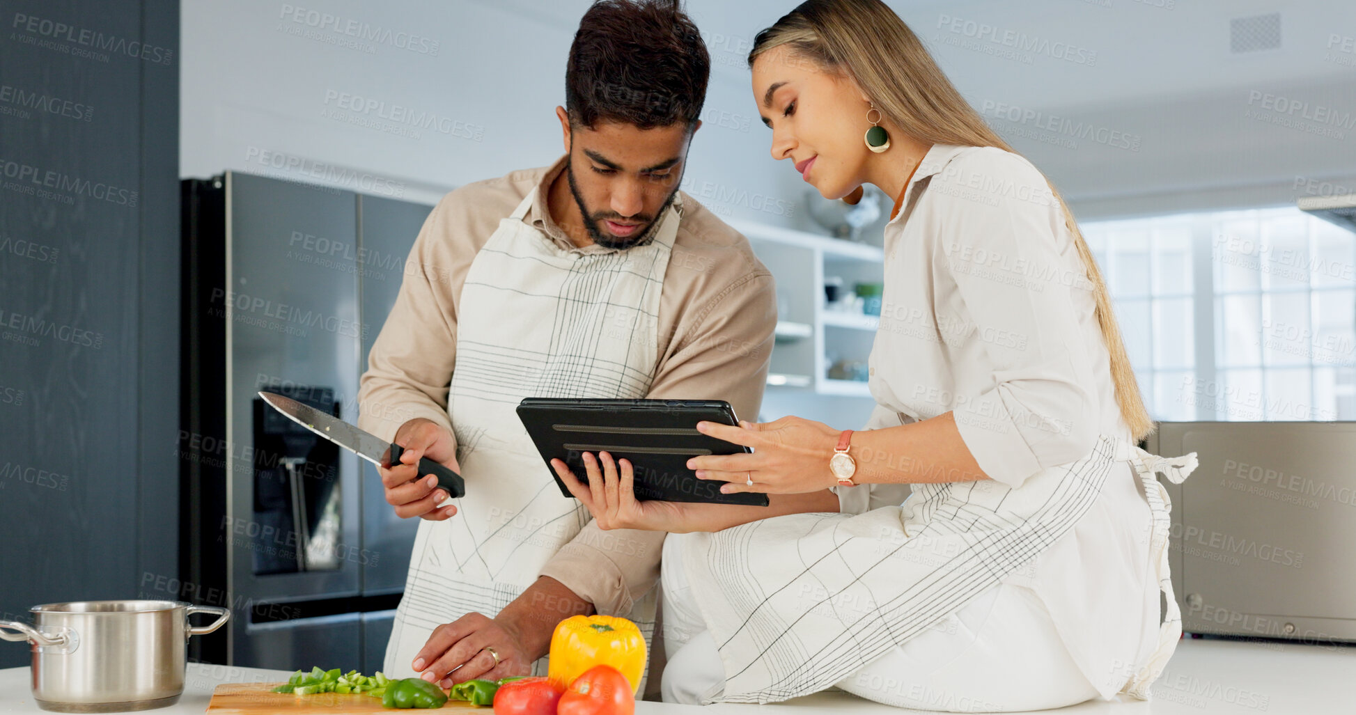 Buy stock photo Tablet, recipe and couple cooking in a kitchen of the home together for health, diet or nutrition. Technology, food or instructions for a meal with a man and woman making healthy supper for wellness