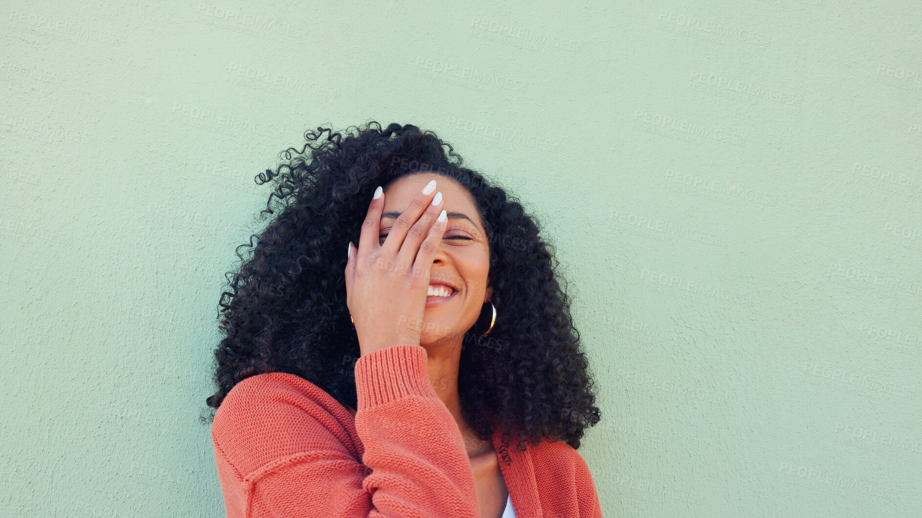 Buy stock photo Woman, playful and hand with curly hair for healthy or wellness with smile at wall. Female, happiness and care for curly treatment or laughing with energy for natural, cosmetic or results in style