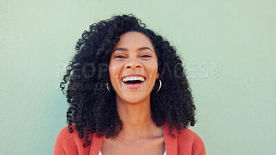 Smile, laughing and happy black woman on green wall background. Portrait face of funny, young and comedy young female with natural afro hair, freedom and happiness for life, motivation and crazy joke