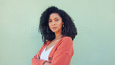 Black woman, confident beauty and young model pose for portrait with afro hair on green background. African girl in orange sweater, fold arms with cool serious face and casual fashion lifestyle