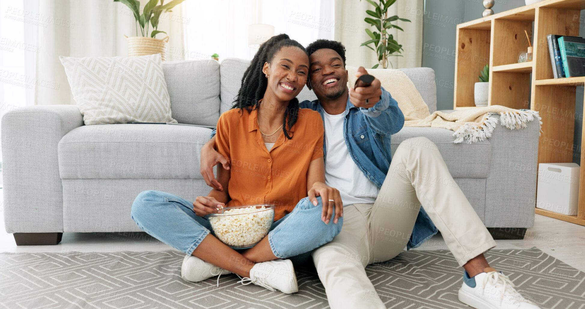 Buy stock photo Happy, black couple and watching tv with popcorn for movie, show or video in home, living room or house. Dating, man and woman relax with media on television, channel or streaming a series online