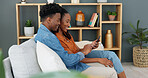 Internet, technology and couple with phone on sofa in living room. Black man teaching young woman how to use banking app, online shopping or fintech on a smartphone, while sitting on a couch at home.