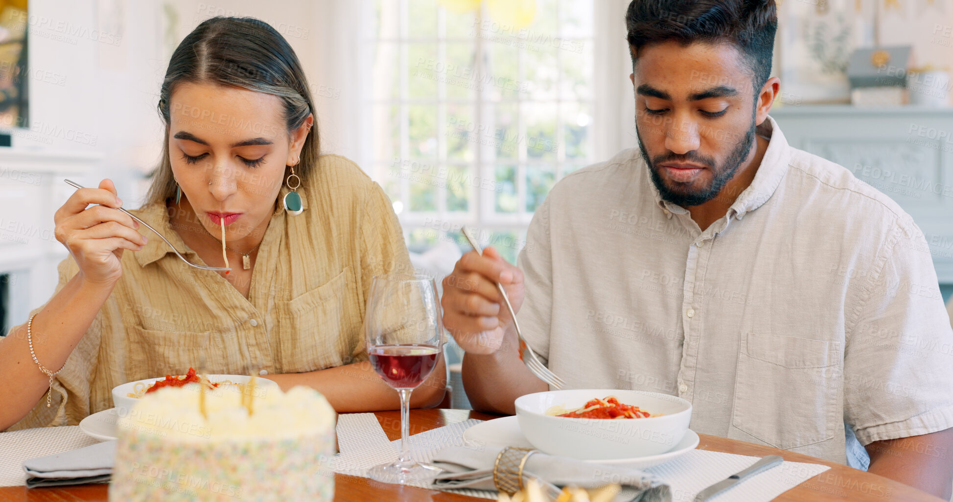 Buy stock photo Birthday cake, funny and couple eating spaghetti on a romantic dinner home with a Italian meal together. Love, man and woman on date with pasta, food and anniversary with celebration at table