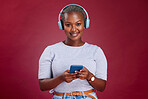Happy black woman, phone or headphones for music, podcast or listening to radio in red studio background. Smile, wireless earphones of girl for relax audio, smartphone or social media networking.