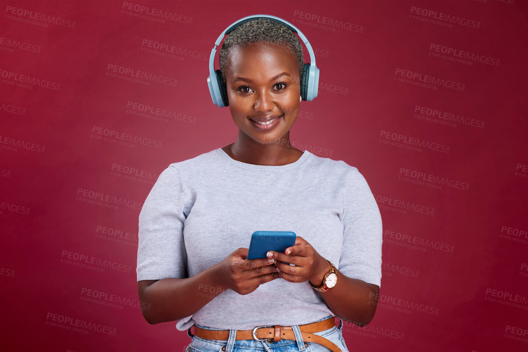 Buy stock photo Happy black woman, phone or headphones for music, podcast or listening to radio in red studio background. Smile, wireless earphones of girl for relax audio, smartphone or social media networking.