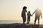 Silhouette, beach and a family with kids by the ocean, holding hands in nature at sunset from the back. Summer, travel or love with a mother, father and child having fun while bonding at the sea