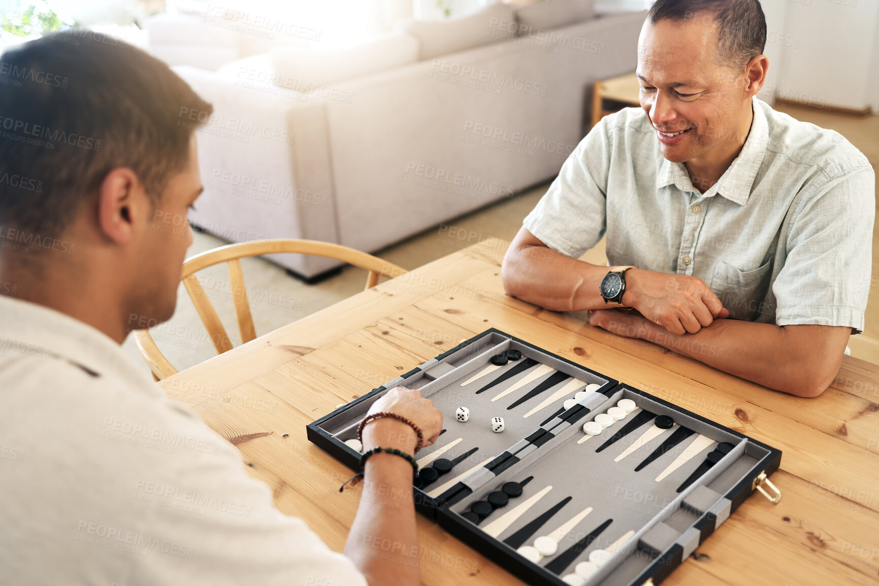 Buy stock photo Senior, man and play backgammon in home with focus, strategy and contest for thinking, moving or son by table. Elderly man, board game competition and relax with bonding, love and family house lounge