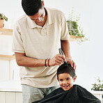 Family, children and haircut with a father shaving the hair of his son together in the home for grooming. Kids, barber and hairstyle with a man cutting the head of his son as a hairdresser in a house