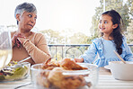 Food, family and grandmother with girl a table for lunch, party or social gathering on a patio. Love, dinner and senior woman looking at grandchild while sharing a meal, happy and smile outdoors