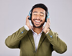 Music, headphones and business man singing in studio isolated on a gray background. Ceo, entrepreneur and smile of happy male singer streaming, listening and enjoying podcast, radio and song album.