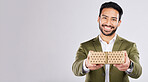 Gift, box and portrait of a man in a studio for a celebration or birthday or event with mockup space. Present, happy and male model from Mexico giving a souvenir with happiness by a gray background.