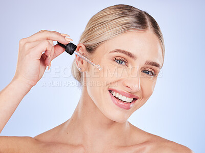 Buy stock photo Face, portrait and skincare of woman with serum in studio isolated on a blue background. Dermatology, beauty cosmetics and happy female model apply hyaluronic acid, retinol or essential oil product.