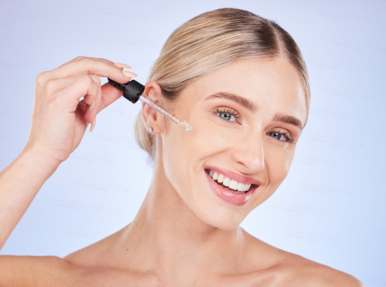 Buy stock photo Face, portrait and skincare of woman with serum in studio isolated on a blue background. Dermatology, beauty cosmetics and happy female model apply hyaluronic acid, retinol or essential oil product.