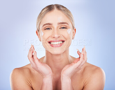 Buy stock photo Portrait, face skincare and woman with cream in studio isolated on a blue background. Dermatology cosmetics, beauty and happy female model apply lotion, creme or moisturizer product for healthy skin.