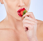 Closeup, strawberry and woman with skincare, healthy lifestyle and girl against a blue studio background. Zoom, female and lady with red fruit, berry and cosmetics for wellness, diet and nutrition