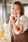 Peace, hand gesture and portrait with an asian woman in a coffee shop, drinking a beverage or refreshment. Face, emoji and cafe with an attractive young female enjoying a smoothie or juice drink