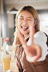 Peace, hand gesture and tongue with an asian woman in a coffee shop, drinking a beverage or refreshment. Eyes closed, emoji and cafe with an attractive young female enjoying a smoothie or juice drink