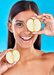 Skincare, smile and portrait of Indian woman with apple slices and facial detox with smile on blue background. Health, wellness and face of model with organic luxury cleaning and grooming cosmetics.