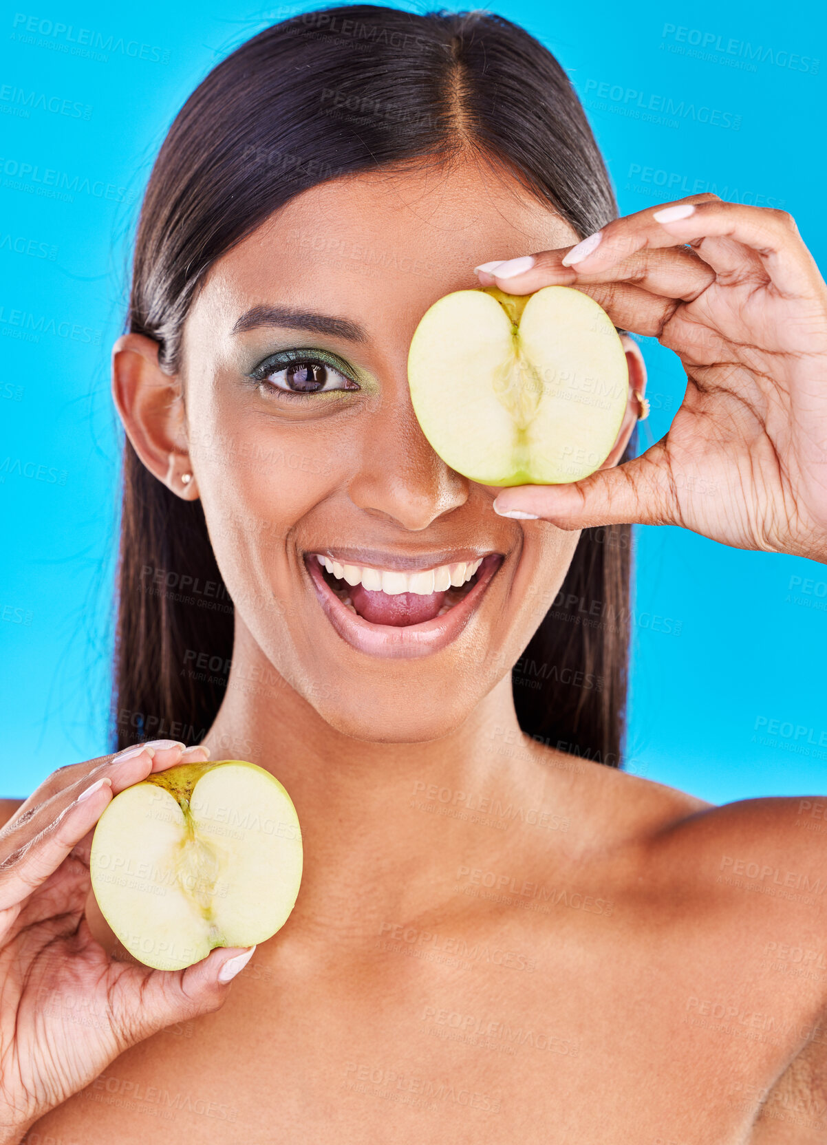 Buy stock photo Skincare, smile and portrait of Indian woman with apple slices and facial detox with fruit on blue background. Health, wellness and face of model with organic luxury cleaning and grooming cosmetics.