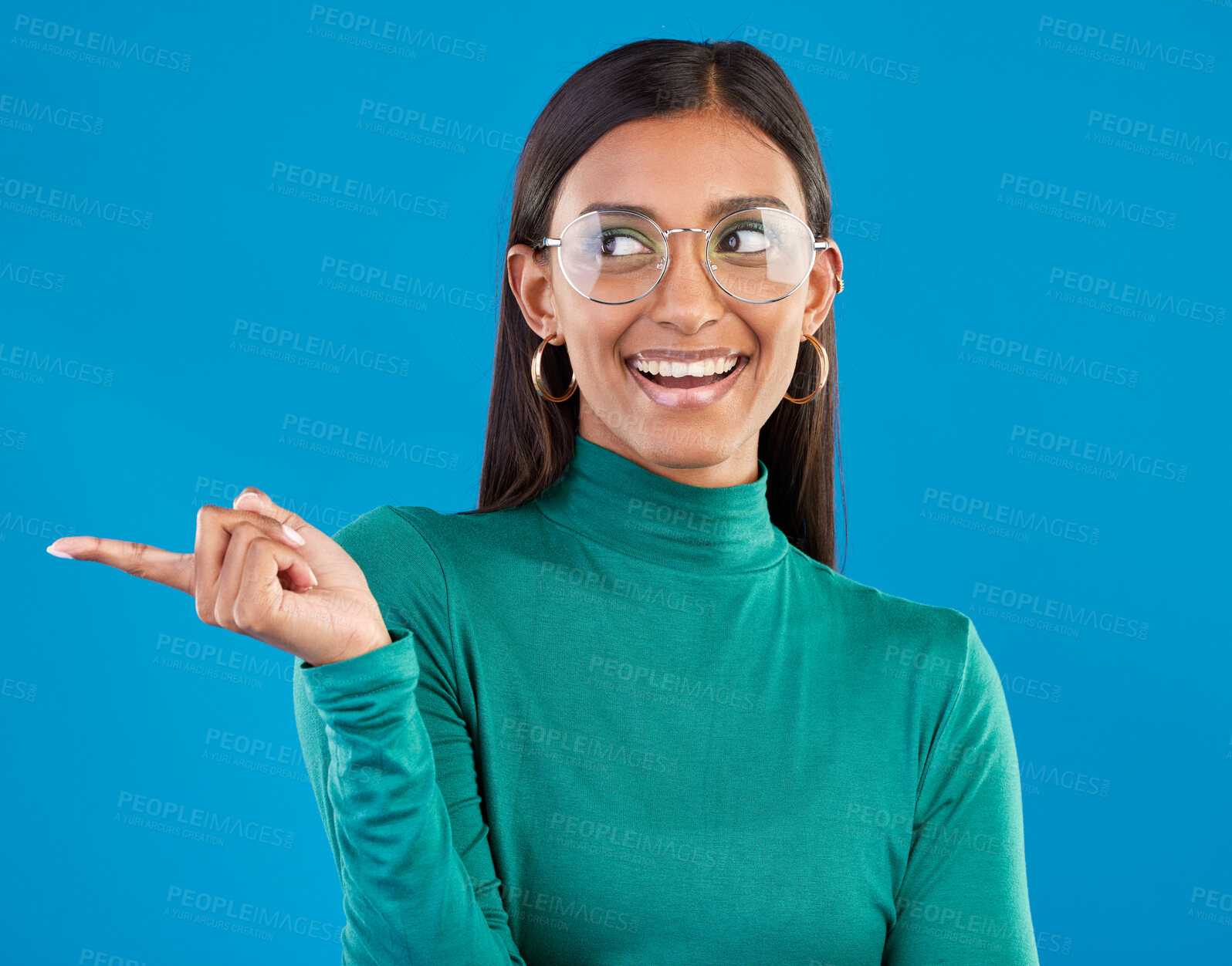 Buy stock photo Mockup, Indian woman and pointing with space, smile and advertising with girl against a blue studio background. Female, lady and gesture for direction, happiness and branding development with smile