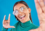Woman, face and fashion selfie with rock on hand for gen z attitude on a blue background with glasses. Happy model person in studio with excited and cool hand sign or emoji with beauty and motivation