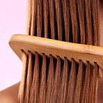 Beauty, comb and wood with hair of woman for health, salon and satisfaction in studio. Wellness, keratin and natural with girl model and self care for cosmetics, brush and shine on pink background